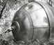 Photograph of the 'hiball', a large metal sphere towed behind two tractors to clear forests.