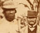 Photograph of miners and their wives posing with the finders of the nugget. Photograph of miners and their wives posing with the finders of the nugget.