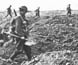 Photograph of Australian troops crossing trenches.